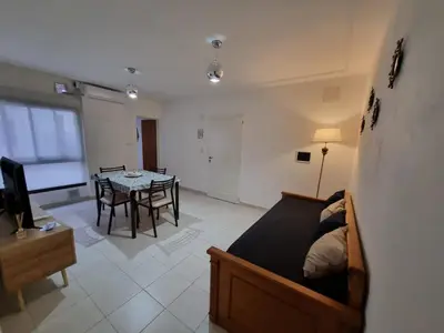 a bedroom with a bed and a dining room with a table at Home in Río Cuarto