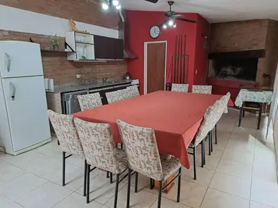 a kitchen with a table with chairs and a white refrigerator at Casa La Nona 5 personas con patio y quincho in Cordoba