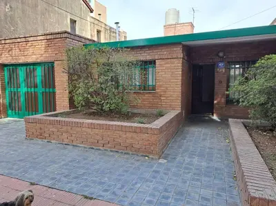 a brick building with a tree in front of it at Casa La Nona 5 personas con patio y quincho in Cordoba