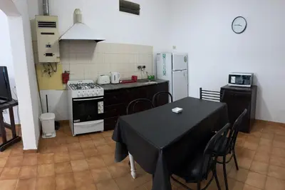 a kitchen with a table and a kitchen with a stove at Casa zona CUCÚ de 2 dormitorios in Villa Carlos Paz