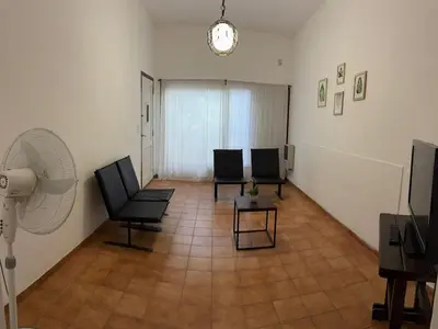 a living room with two chairs and a fan at Casa zona CUCÚ de 2 dormitorios in Villa Carlos Paz