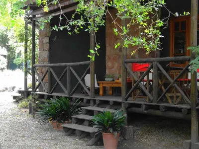 a house with stairs leading to a porch with plants at Puesto Victoria - Adults only in Yacanto