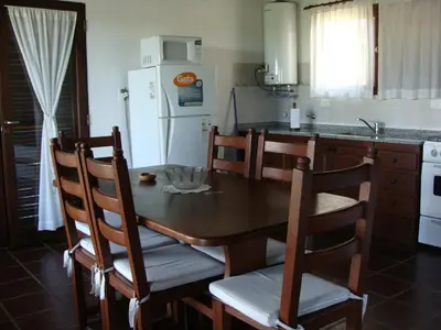 a kitchen with a table and chairs and a refrigerator at Vista del Condor in Villa Ciudad de America
