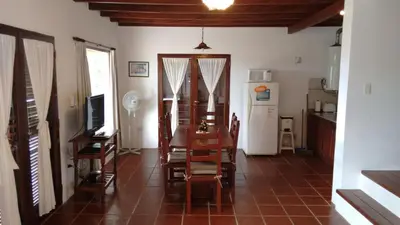 a dining room with a table and a kitchen at Vista del Condor in Villa Ciudad de America