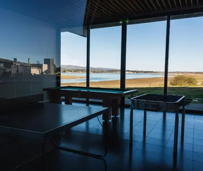two ping pong tables in a room with large windows at Depto - Lago los Molinos in Potrero de Garay