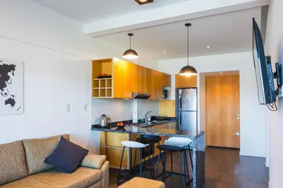 a living room with a couch and a kitchen at Depto - Lago los Molinos in Potrero de Garay
