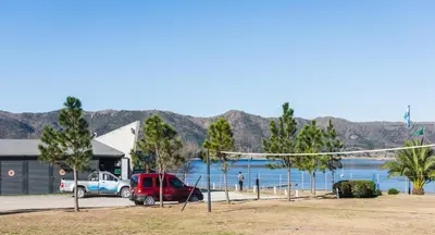 a group of cars parked in front of a beach at Depto - Lago los Molinos in Potrero de Garay