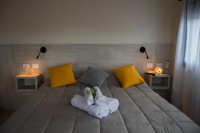 a bed with towels on it with two lamps at Complejo Moras I in Almafuerte