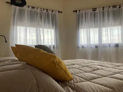 a bed with a yellow pillow on it in a bedroom at Complejo Moras I in Almafuerte