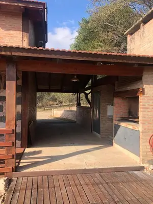 a large brick building with an open garage at Cabaña EL GALLO in Villa General Belgrano