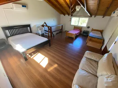 a living room with a couch and wooden floors at Cabaña EL GALLO in Villa General Belgrano