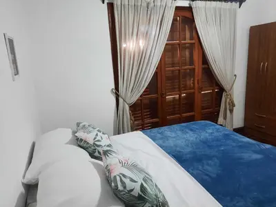 a bedroom with a bed and a window with curtains at Why Not Guemes in Cordoba