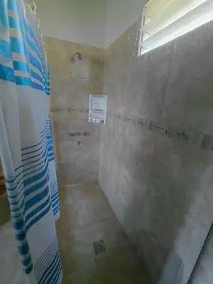 a bathroom with a shower with a glass door at Casa en Cabalango in Cavalango