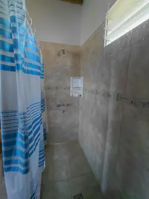 a shower with a blue and white shower curtain in a bathroom at Casa en Cabalango in Cavalango