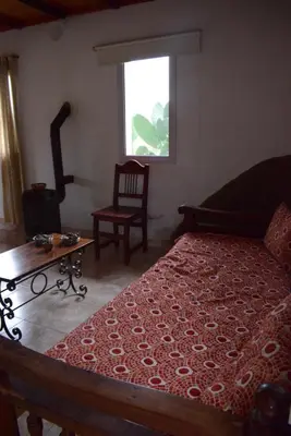 a bedroom with a bed and a chair and a window at Casa en Cabalango in Cavalango