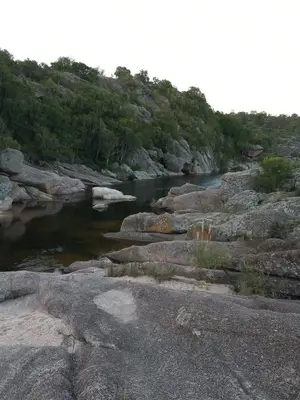 a river with rocks and trees in the background at Casa en Cabalango in Cavalango