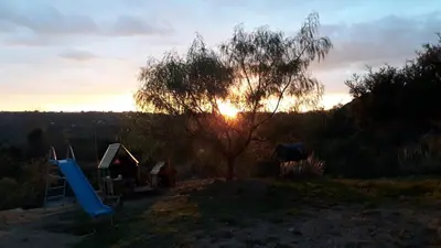 a sunset with a tree and a playground at Casa en Cabalango in Cavalango