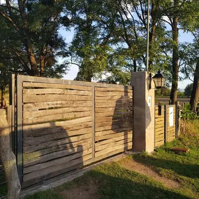 a wooden fence with a gate and a street light at Casa de campo boutique a 18 minutos de Merlo in Cortaderas