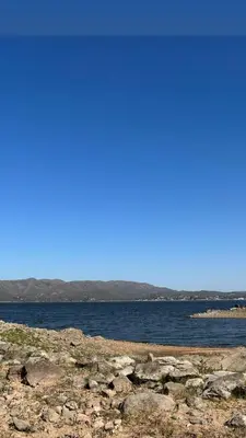 a large body of water with rocks and the ocean at Pasionaria Lake in Villa Parque Siquiman