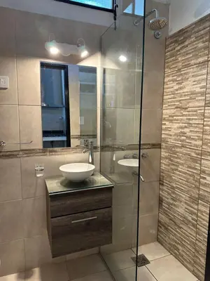 a bathroom with a sink and a glass shower at Pasionaria Lake in Villa Parque Siquiman