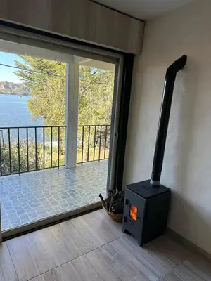 a black stove in a room with a balcony at Pasionaria Lake in Villa Parque Siquiman