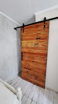a wooden sliding door in a room with a bed at La aurora in Pantanillo