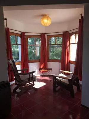 a living room with red curtains and a table and chairs at Rakum Apartamentos Turísticos in Villa General Belgrano
