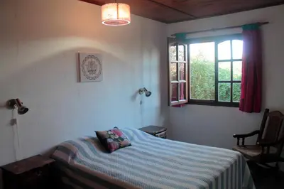 a bedroom with a bed with a blue blanket and a window at Rakum Apartamentos Turísticos in Villa General Belgrano
