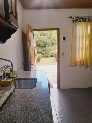 a kitchen with a sink and a door to a yard at Rakum Apartamentos Turísticos in Villa General Belgrano
