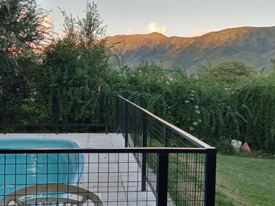 a deck with a swimming pool and a fence at Ojos de cielo Monoambientes para 2 y 3 personas in Bialet Massé
