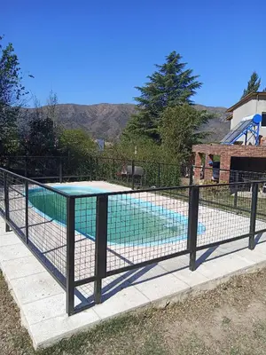 a tennis court in a fence next to a pool at Ojos de cielo Monoambientes para 2 y 3 personas in Bialet Massé