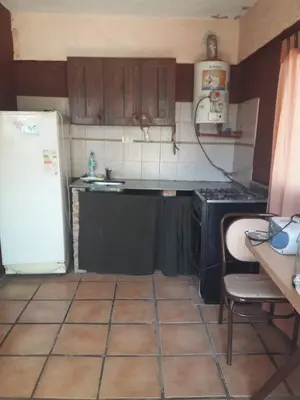a kitchen with a stove and a refrigerator and a table at Ojos de cielo Monoambientes para 2 y 3 personas in Bialet Massé