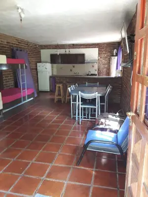 a room with a table and chairs and a kitchen at Ojos de cielo Monoambientes para 2 y 3 personas in Bialet Massé