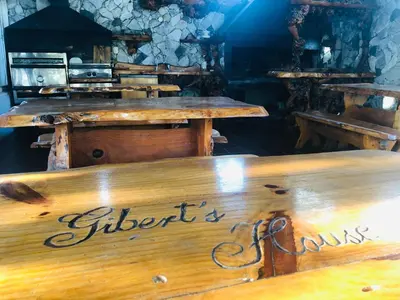 a restaurant with wooden tables and a sign that says differentiates at Apart-Hotel Gibert's House in Villa Carlos Paz