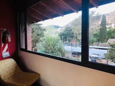a window with a view of a parking lot at Apart-Hotel Gibert's House in Villa Carlos Paz