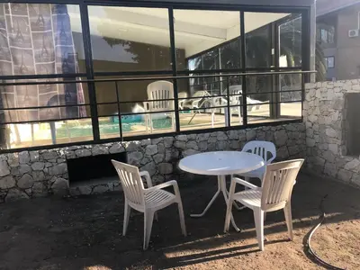 a table and two chairs and a table and a table at Apart-Hotel Gibert's House in Villa Carlos Paz