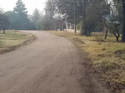 a dirt road with trees on the side of it at La Estacion in Santa Rosa de Calamuchita