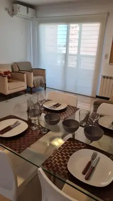 a glass table with plates and wine glasses on it at Ituzaingó 1054 - cochera, pileta y quincho- in Cordoba