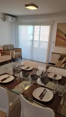 a living room with a table with plates and wine glasses at Ituzaingó 1054 - cochera, pileta y quincho- in Cordoba