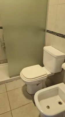 a bathroom with a white toilet and a sink at Ituzaingó 1054 - cochera, pileta y quincho- in Cordoba