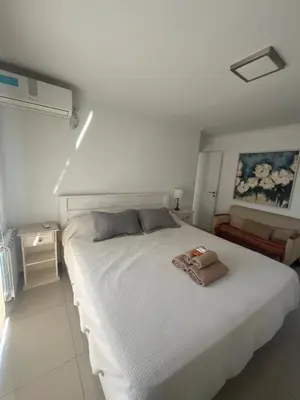 a bedroom with a white bed with two towels on it at Ituzaingó 1054 - cochera, pileta y quincho- in Cordoba
