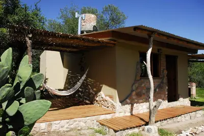 a house with a hammock in front of it at TrinidadTraslasierra-CASATUNA in Las Rabonas