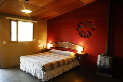 a bedroom with a bed in a red wall at TrinidadTraslasierra-CASATUNA in Las Rabonas