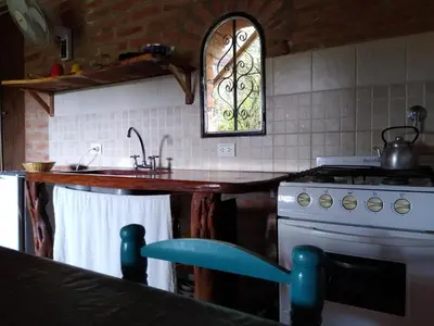 a kitchen with a sink and a stove at TrinidadTraslasierra-CASATUNA in Las Rabonas