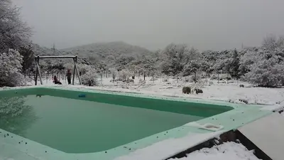 a swimming pool covered in snow with trees in the background at TrinidadTraslasierra-CASATUNA in Las Rabonas