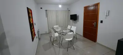 a dining room with a glass table and white chairs at Village Tower in Villa Carlos Paz