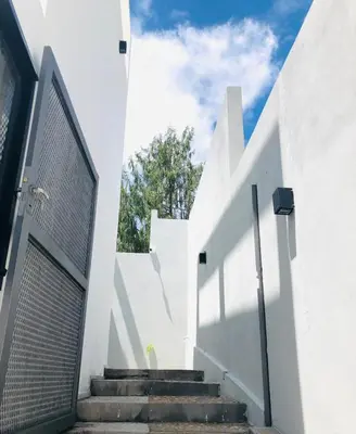 a stairway leading to a white building with a gate at Sierra Alta Carlos Paz in Villa Carlos Paz