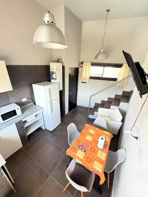 a kitchen with a table and chairs and a refrigerator at Sierra Alta Carlos Paz in Villa Carlos Paz