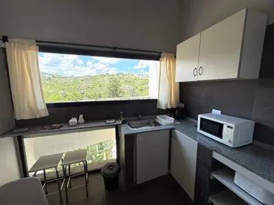 a small kitchen with a microwave and a window at Sierra Alta Carlos Paz in Villa Carlos Paz