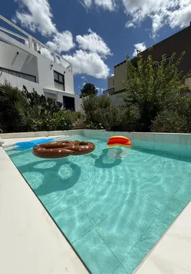 a swimming pool with a frisbee and two brown frisbees at Sierra Alta Carlos Paz in Villa Carlos Paz